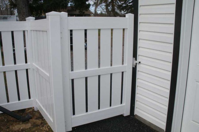 white semi private vinyl fence attached to home