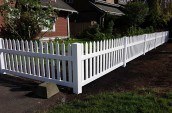 vinyl picket fence surrounding residential home backyard