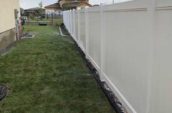 pvc vinyl privacy fence lining side of home backyard