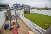 kinsmen vinyl picket fence enclosing shed and play area in home backyard