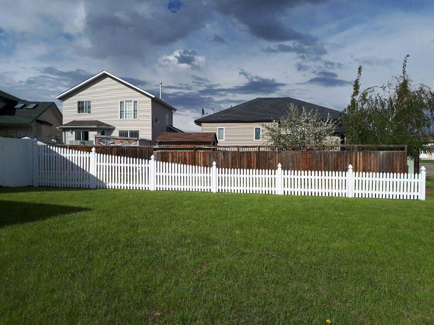 rising vinyl picket fence around home backyard